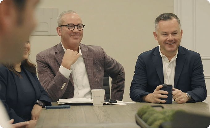 Dustin Davis and Bryan Evans smiling in conference meeting