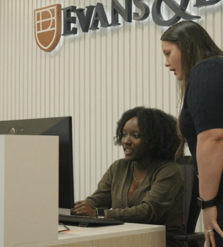 Jessi Smith speaking with Myla R. Carey at front desk of Evans & Davis